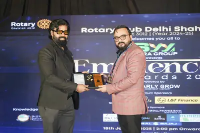 Eminence MSME Awards: Awardee holding an award plaque on stage