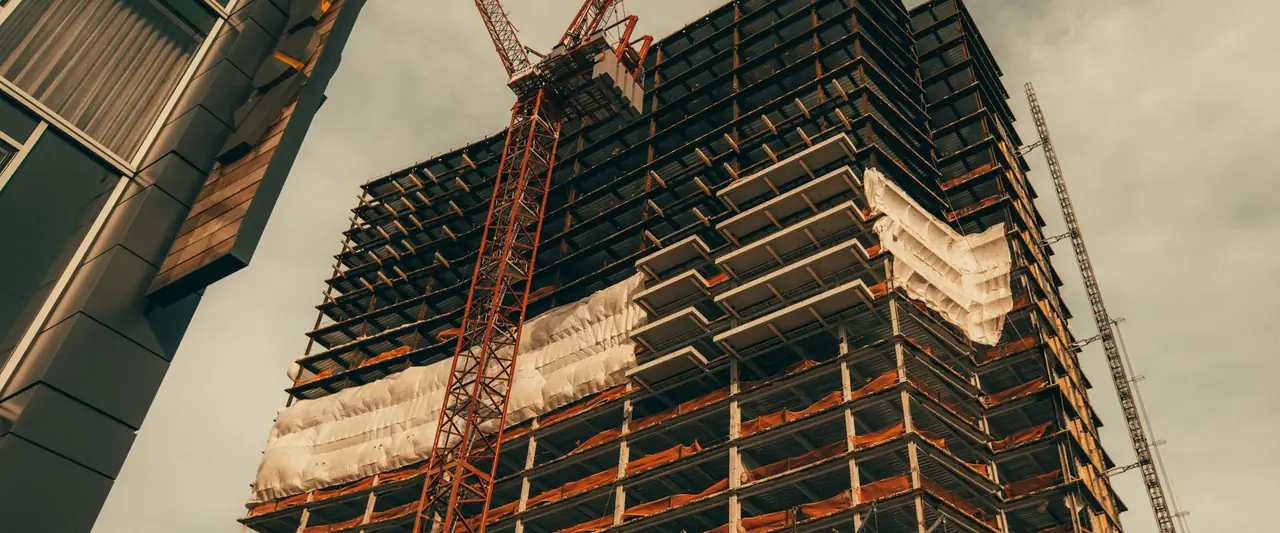 High-rise building under construction with a tower crane