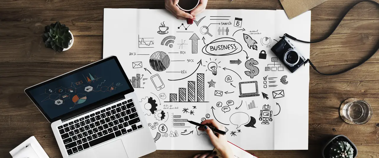 Marketing plan sketches beside a laptop