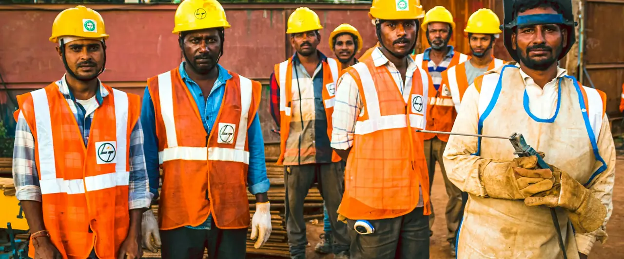 Workers in safety helmets and high-visibility vests