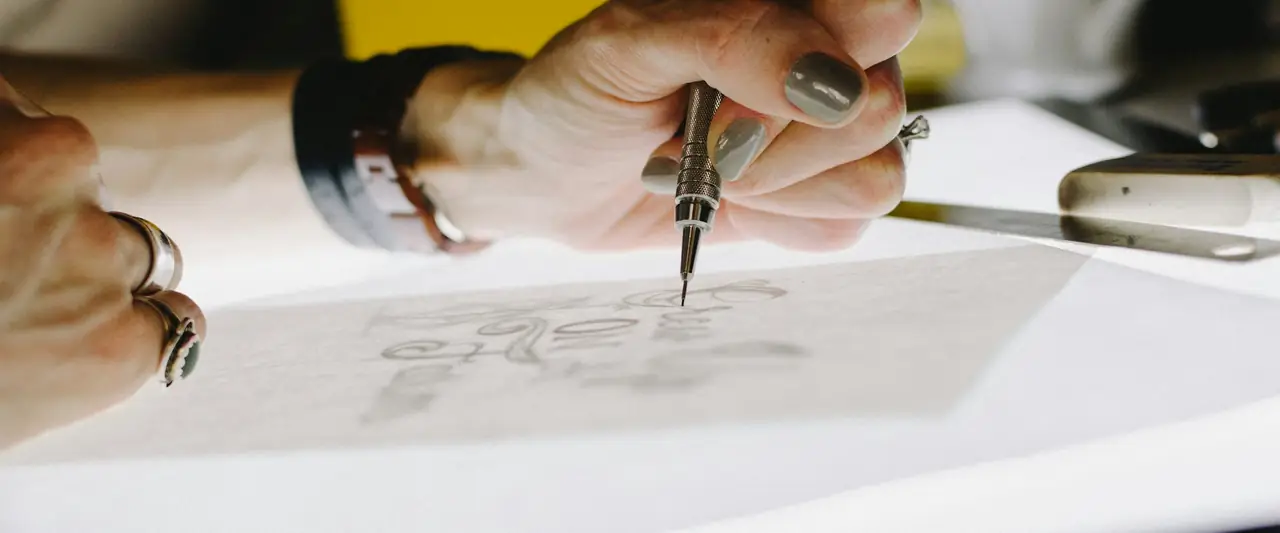 Designer sketching a logo on tracing paper